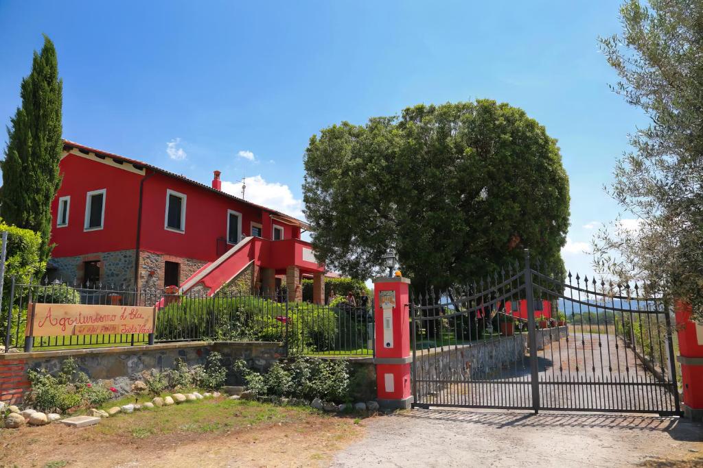 una vieja cabina de teléfono rojo delante de una casa roja en Agriturismo L'Elce en Bolsena