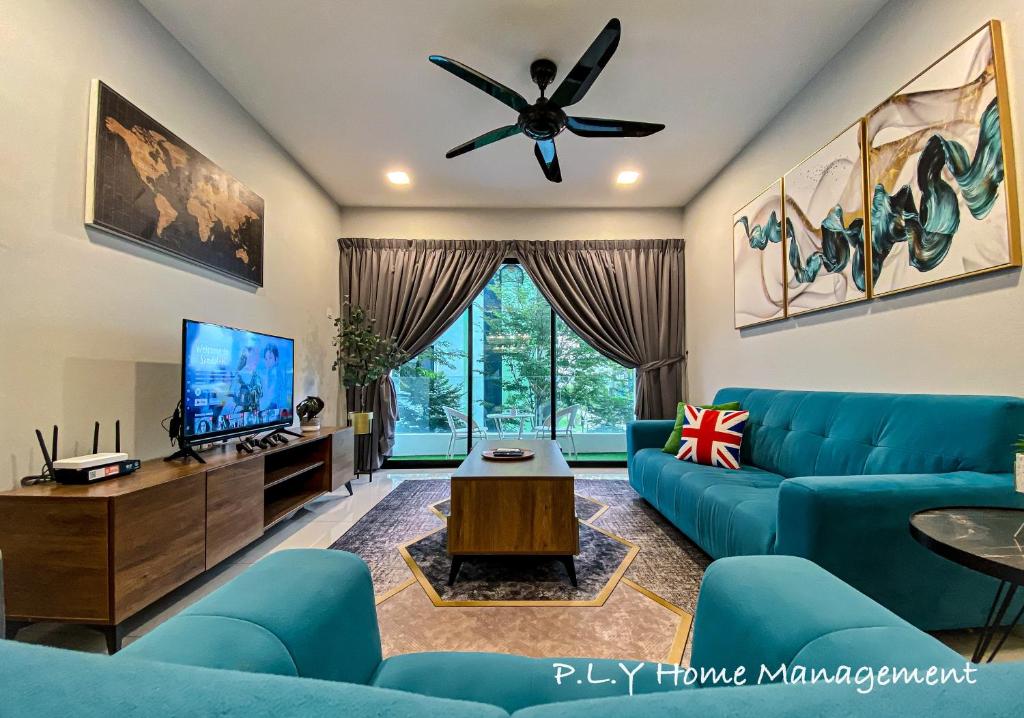 a living room with blue couches and a tv at Crystal Cozy Suite PoolView Netflix Waterpark@ Ipoh Station 18 in Ipoh