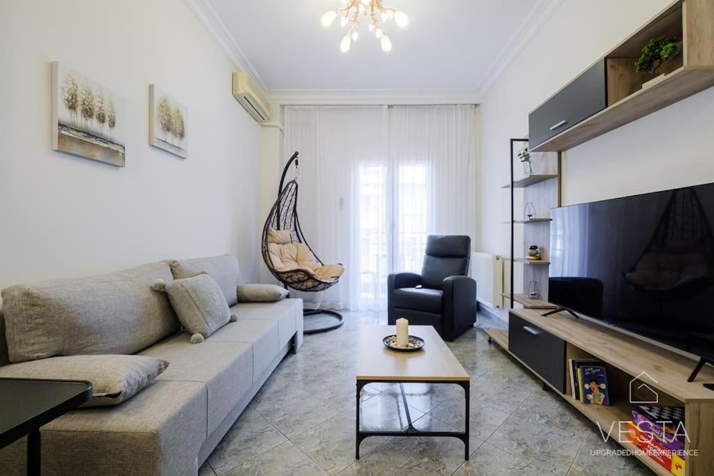 a living room with a couch and a tv at Origami Urban Residence, Vesta Philoxenia in Thessaloniki