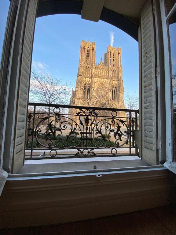 une fenêtre ouverte avec vue sur la cathédrale dans l'établissement By Le PARVIS, à Reims