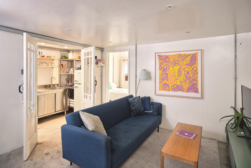 a living room with a blue couch and a table at Unique Georgian Garden Flat in Central Margate in Margate