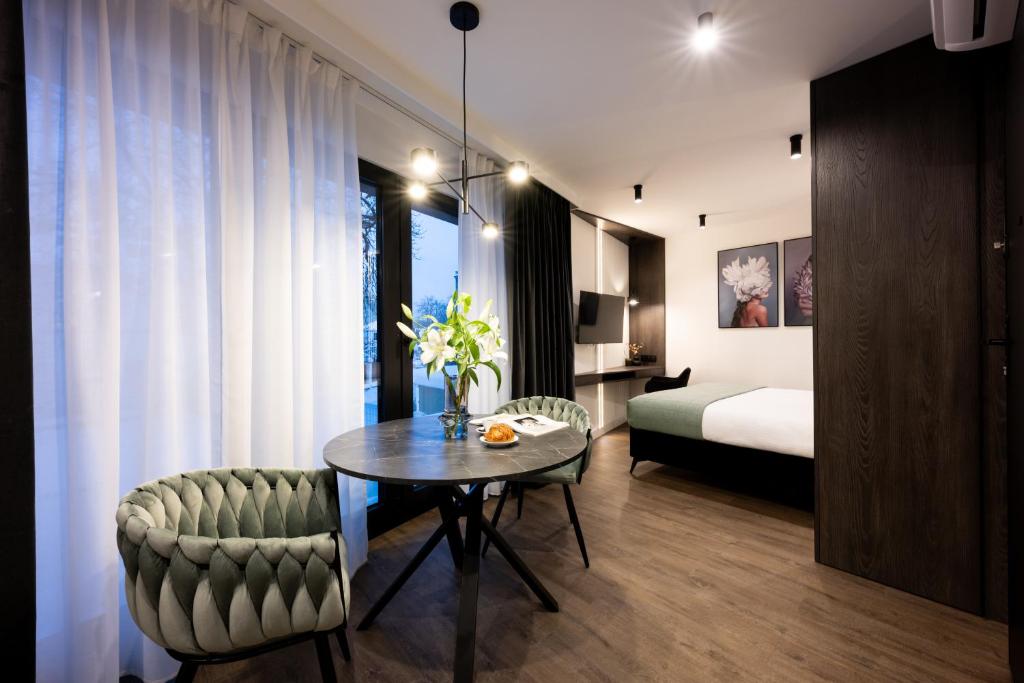 a room with a table and a bed and a bedroom at Native Apartments Kościuszki 39 in Krakow