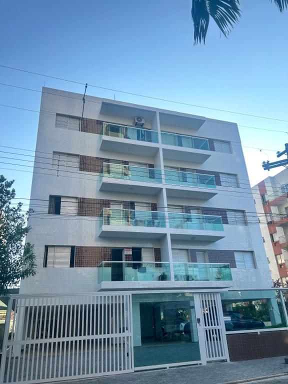 un edificio alto con balcones a un lado. en Apartamento Guaruja Enseada, en Guarujá