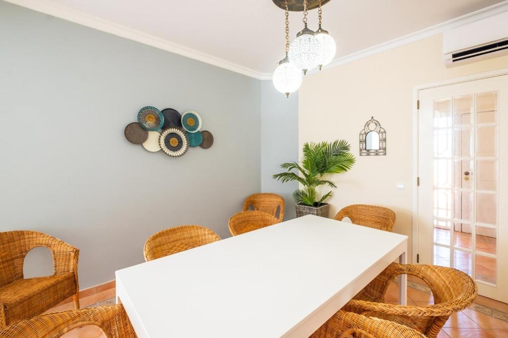 a dining room with a white table and chairs at Villa alhabu in Albufeira