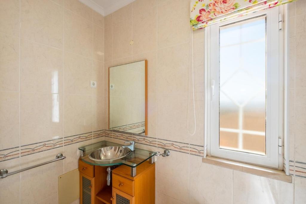 a bathroom with a sink and a window at Villa alhabu in Albufeira
