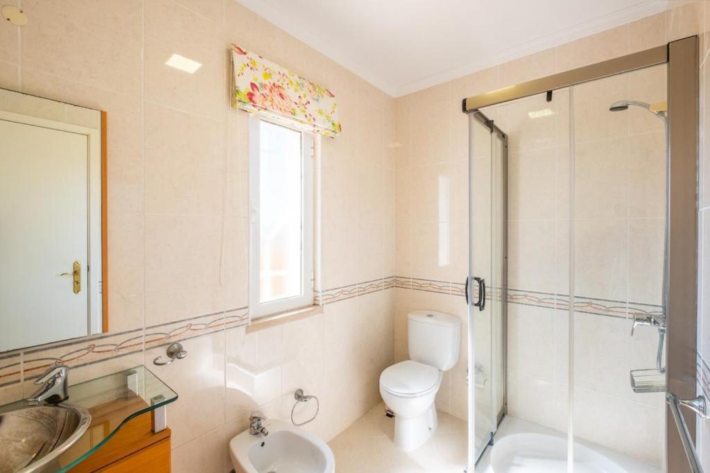a bathroom with a toilet and a sink and a shower at Villa alhabu in Albufeira