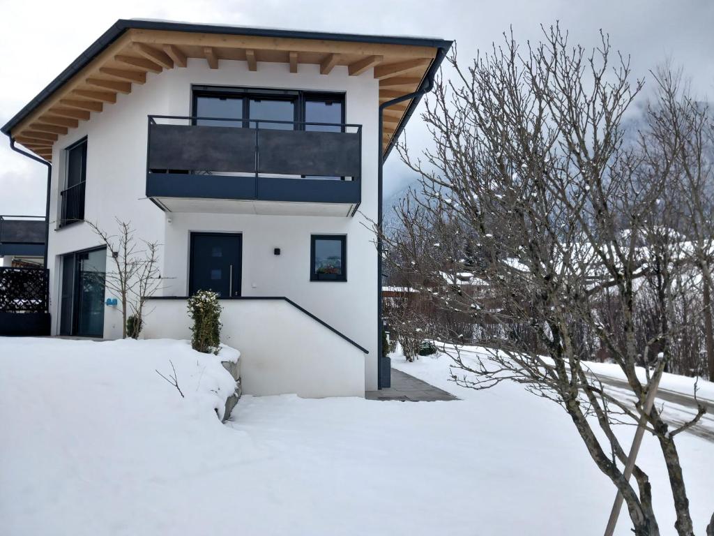 a white house in the snow at Ferienwohnung Riedmann in Söll