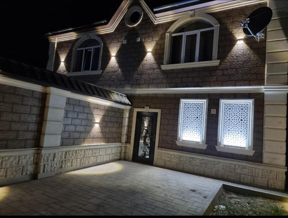 een stenen huis met een deur en ramen 's nachts bij Beautiful Villa in Qusar