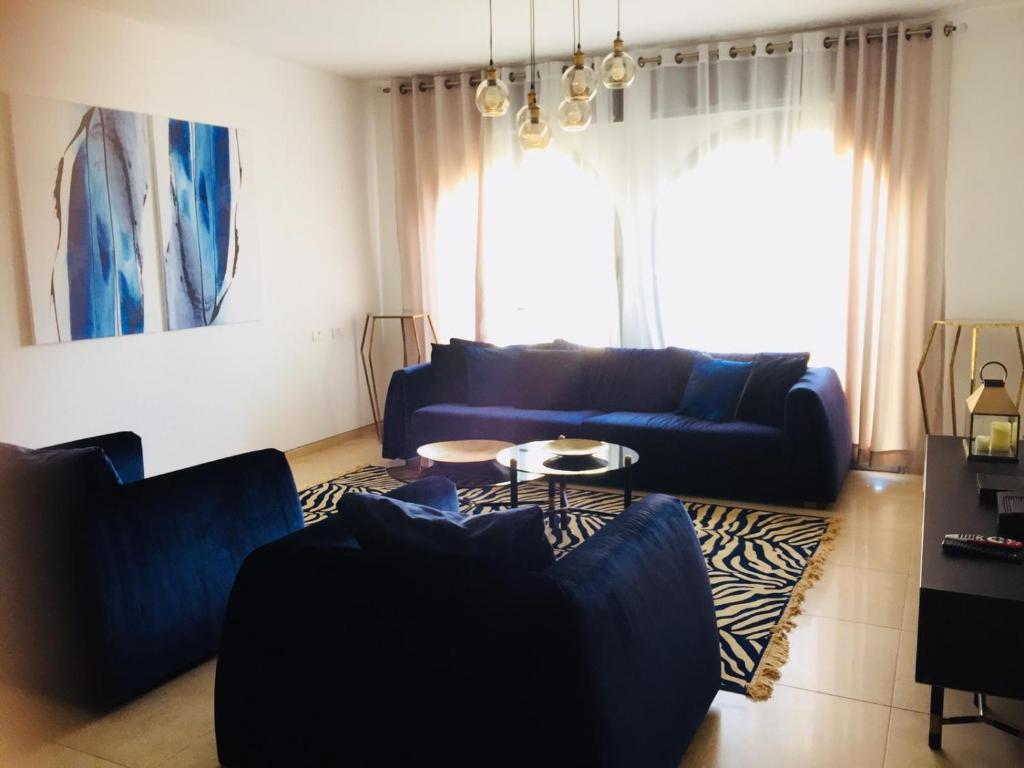 a living room with a blue couch and a table at Harav Kuk Royal Suites - Alefimmoed in Jerusalem