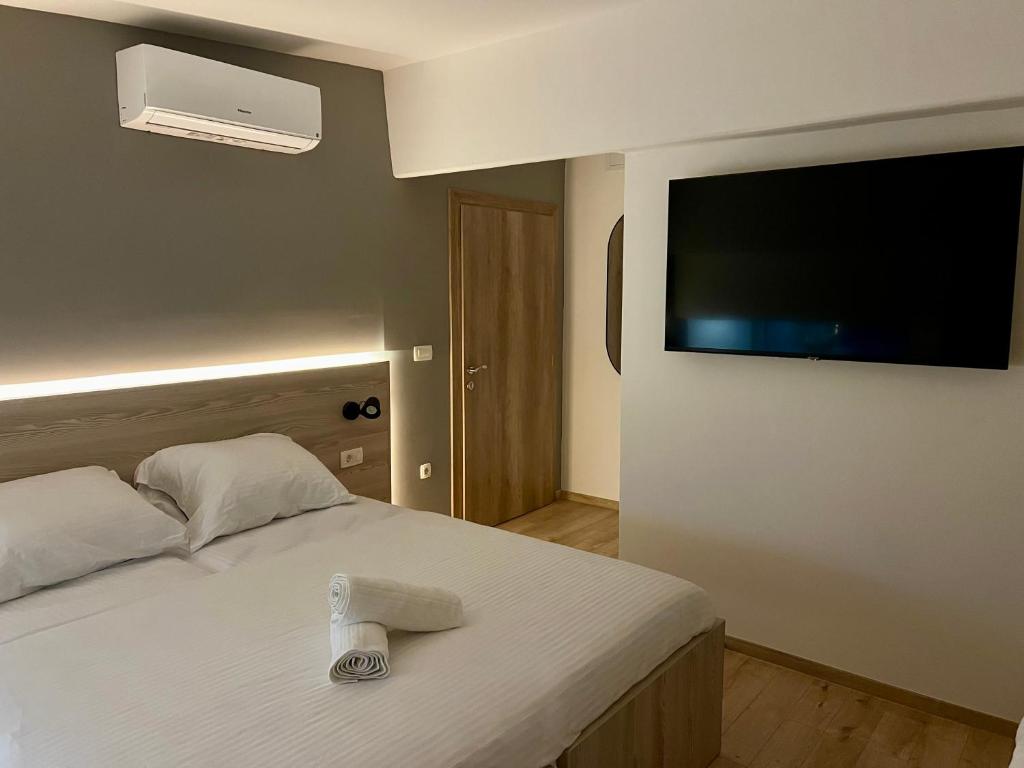a bedroom with a bed and a flat screen tv at Borsa Rooms in Mostar