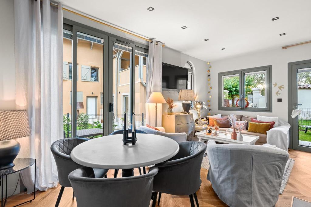 sala de estar con mesa y sillas en La Villa Serenna - Appartement avec jardin, en Écully