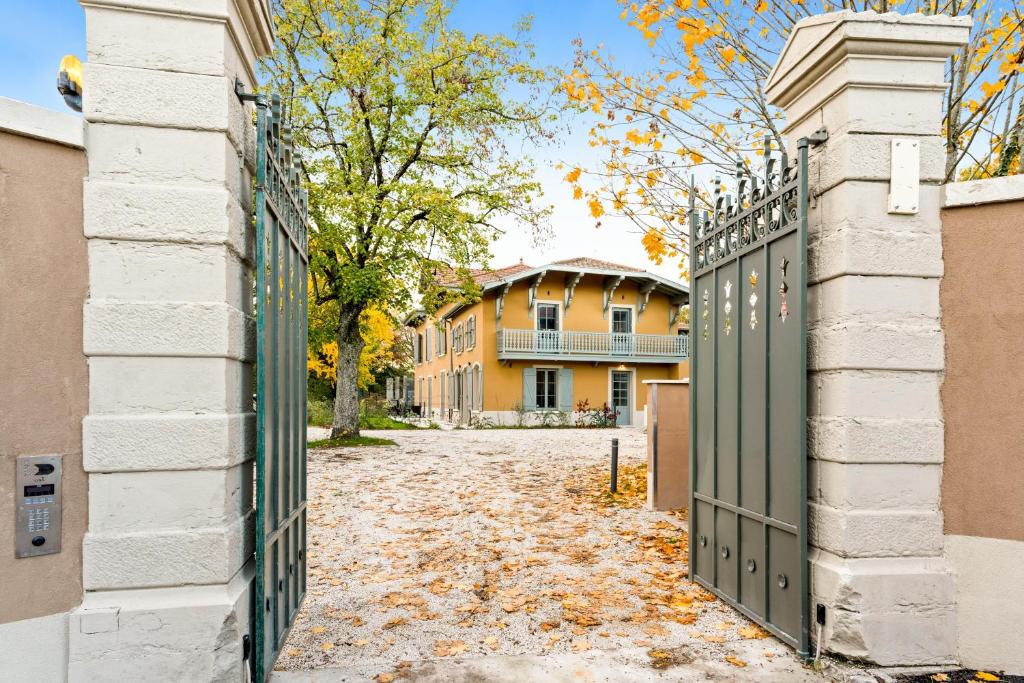 an entrance to a building with a green gate at La Villa Serenna - Appt avec jardin, 15 mn de Lyon in Écully