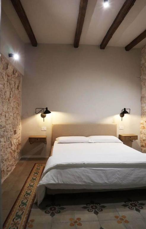 een slaapkamer met een groot wit bed en 2 verlichting bij La Casetta b & b in Turi