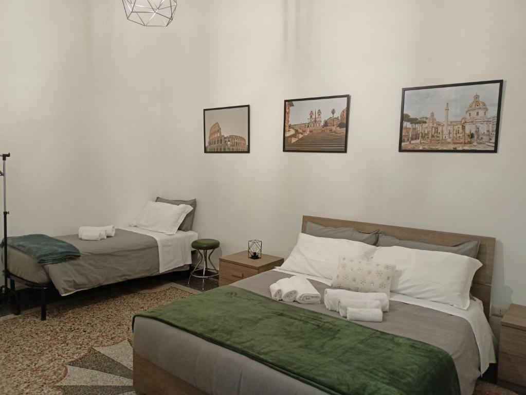 - une chambre avec 2 lits et des photos sur le mur dans l'établissement Rome - Termini House, à Rome