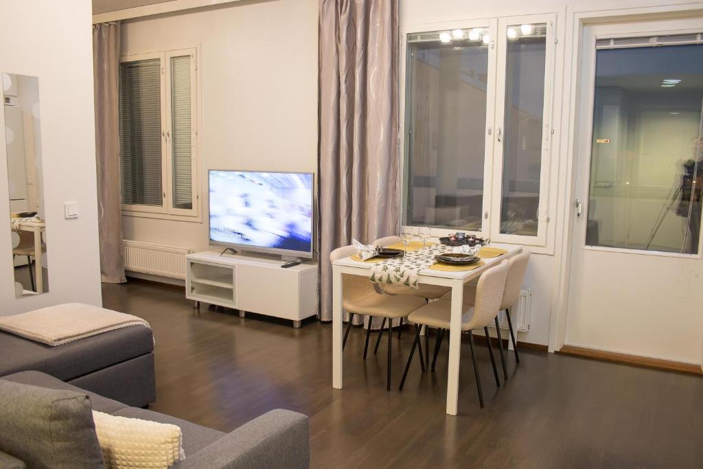 a living room with a table and a television at Lahti Furn House in Lahti
