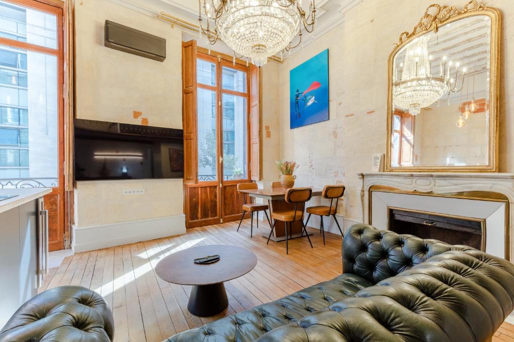 ein Wohnzimmer mit einem Sofa und einem Tisch in der Unterkunft LA Sainte Catherine 215 - Place de Parking in Bordeaux