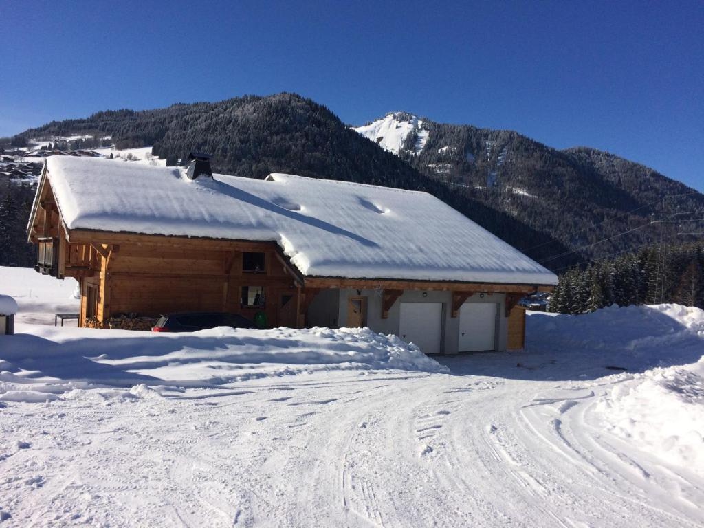 Cabaña cubierta de nieve con techo cubierto de nieve en Chalet La Merlerie en Morzine