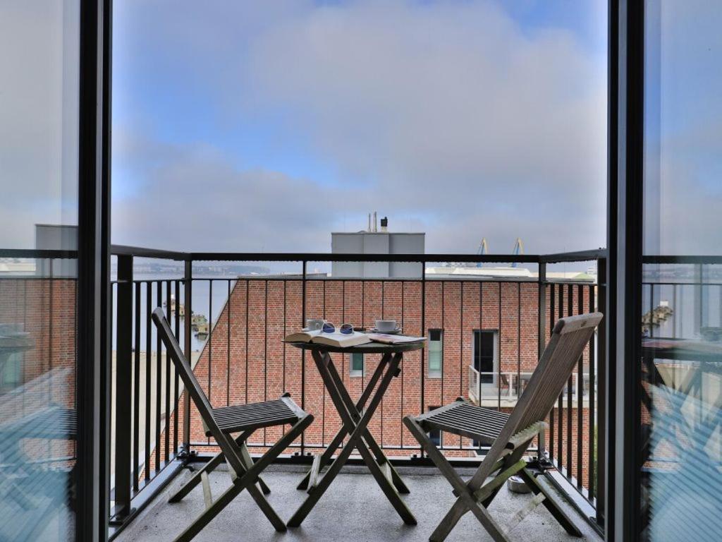 a balcony with a table and two chairs on a balcony at Ohlerich Speicher App_ 27 in Wismar