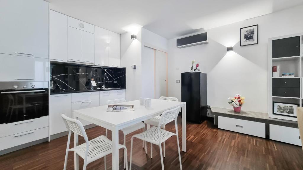 a kitchen with white cabinets and a white table and chairs at Italianway - Torino 57 A in Milan