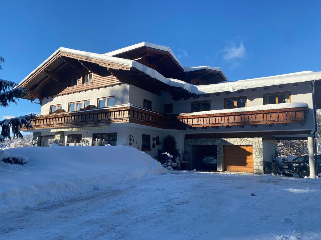 a large house with snow in front of it at Landhaus Wieser in Ramsau am Dachstein