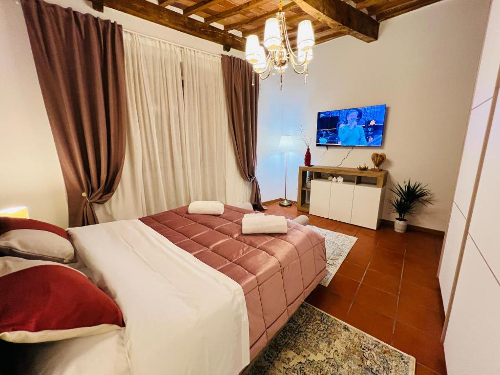 a bedroom with a large bed and a tv at Il cretto bianco in Città di Castello