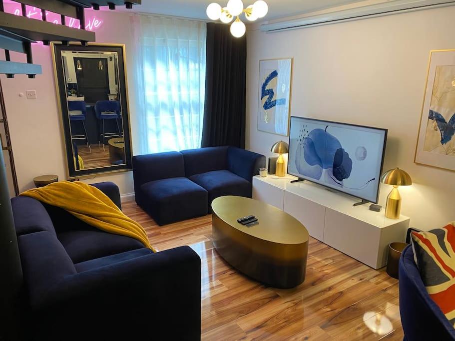 sala de estar con sofá azul y TV en Stunning 2 bed apartment, in the heart of Exeter!, en Exeter