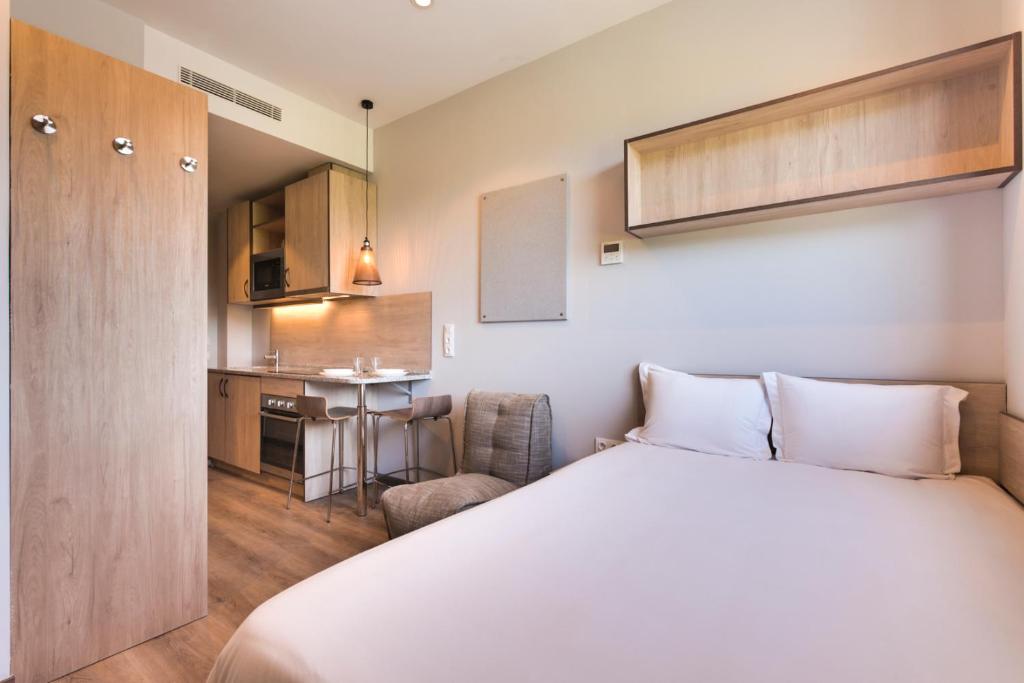pokój hotelowy z łóżkiem i kuchnią w obiekcie Livensa Living Studios Bilbao w mieście Bilbao