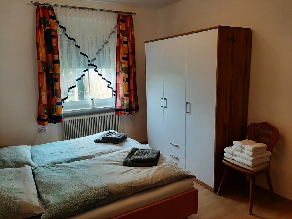 a bedroom with a bed and a cabinet and a window at Ferienwohnung Josef in Steyr