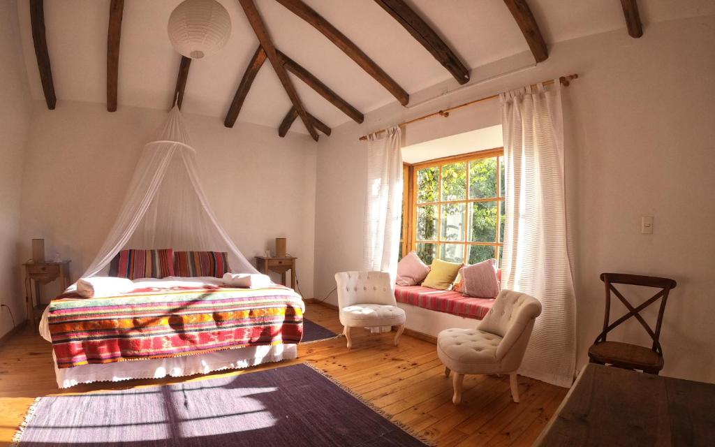 um quarto com uma cama, um sofá e uma janela em Casa Origen em Pirque