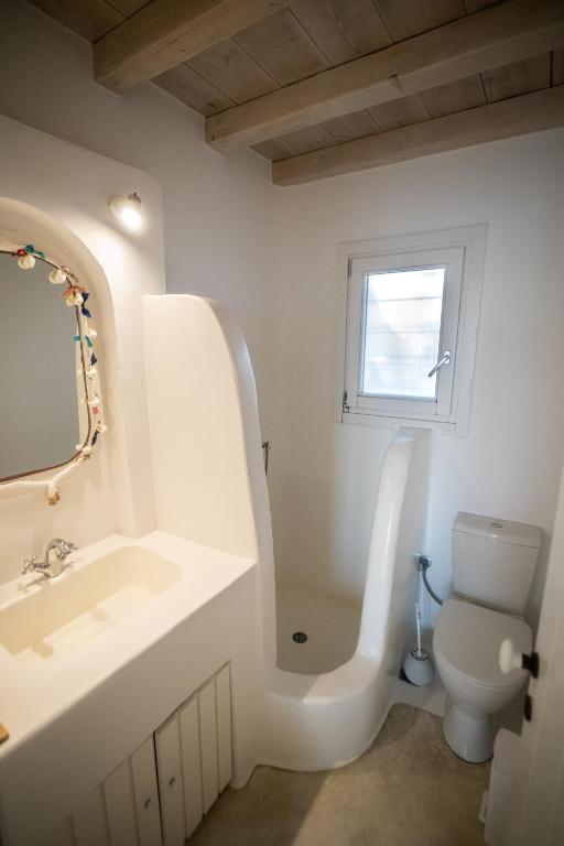 a white bathroom with a sink and a toilet at White Rock Suites &amp; Villas in Houlakia