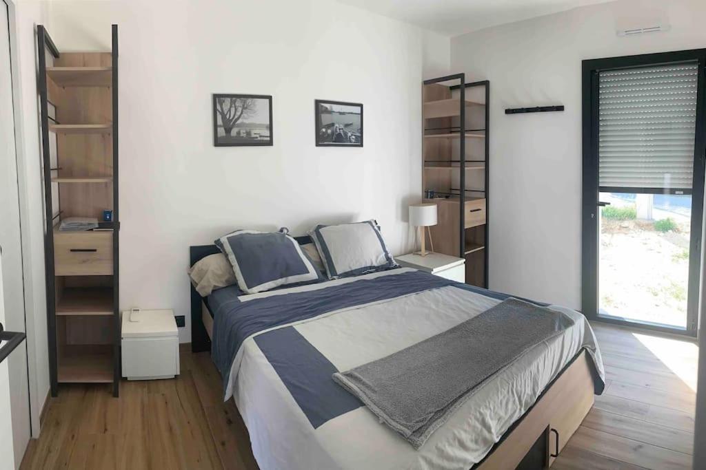 a bedroom with a large bed and a window at T1 ( Saint-Jean-de-Monts ) calme et central in Saint-Jean-de-Monts