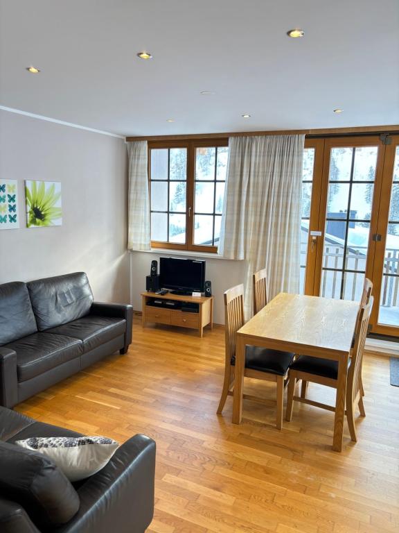 a living room with a table and a couch at Steinadler Schaidberg FL - Skiing Holiday in Obertauern in Obertauern