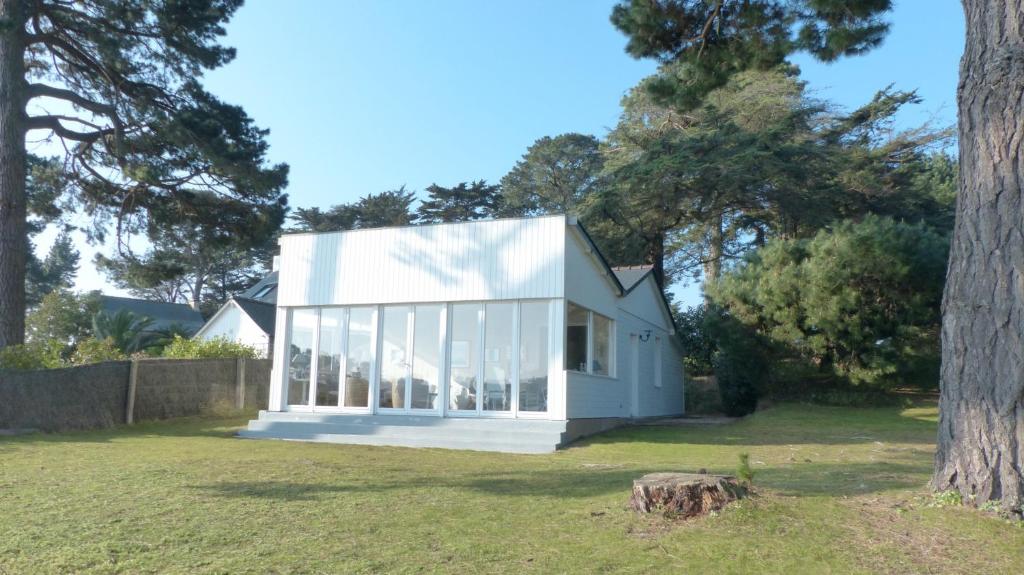 uma casa branca com janelas de vidro num quintal em Cottage maritime avec vue exceptionnelle sur mer em Baden