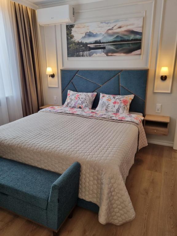 a bedroom with a large bed with a blue headboard at Good Mood Apartment in Klaipėda