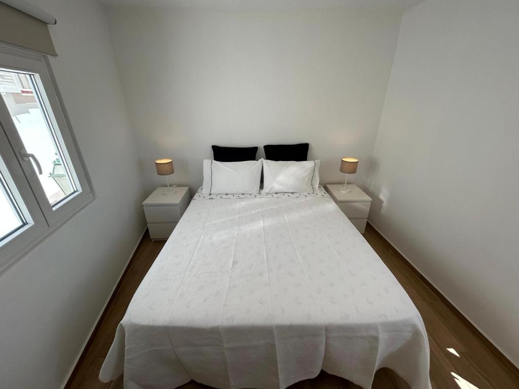 sypialnia z białym łóżkiem i 2 szafkami nocnymi w obiekcie Vista del Mar Guest House w Albufeirze