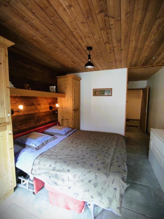 - une chambre avec un grand lit et un plafond en bois dans l'établissement Grand Studio Val Cenis, à Lanslebourg-Mont-Cenis