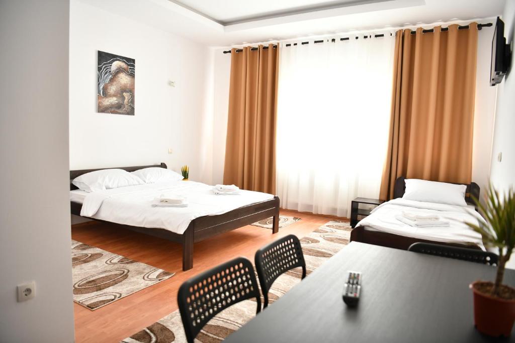 Apartmani swiss Gold في Priboj: غرفة بسريرين وطاولة وكراسي