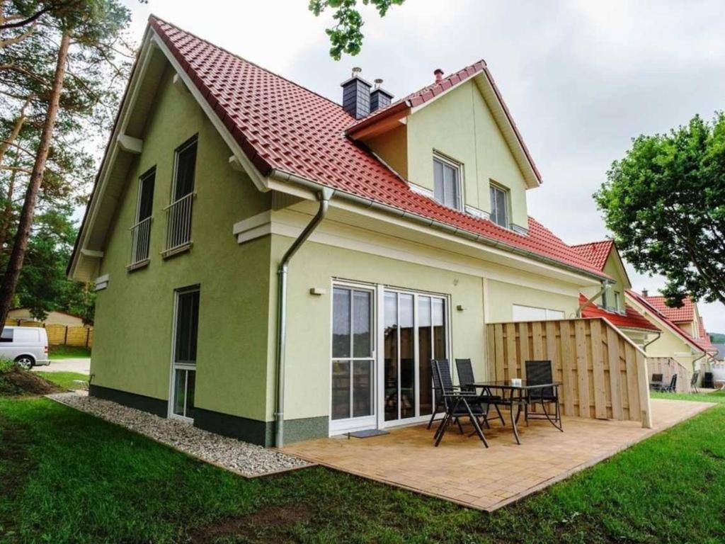 zielony i biały dom z patio w obiekcie Ferienhaus "Felix" mit freiem Blick w mieście Korswandt