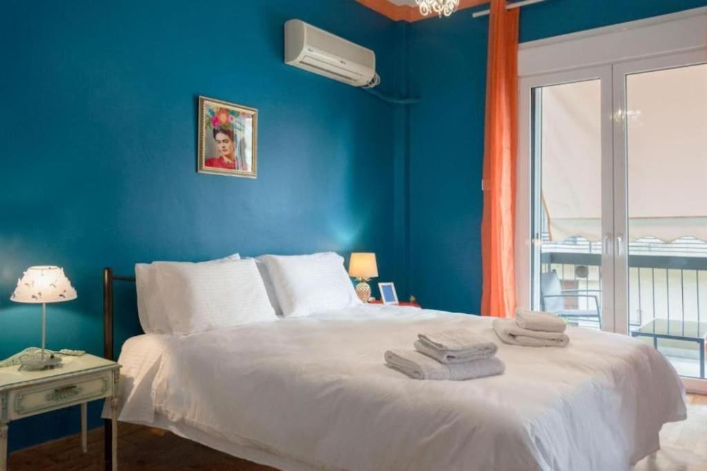 um quarto azul com uma cama com toalhas em Casa de Colores, next to the metro em Atenas