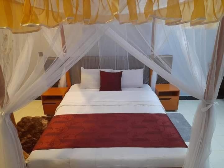 a bedroom with a white bed with a canopy at Villa Martis Kakamega in Kakamega