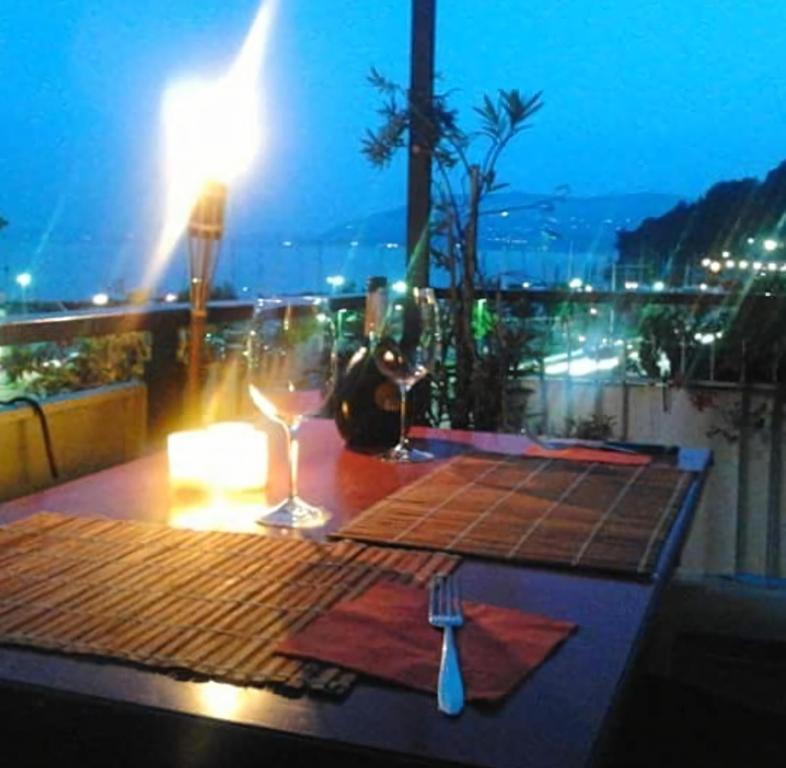einen Tisch mit Gabel und ein Glas Wein auf dem Balkon in der Unterkunft Appartamento Chic Vista Lago - Casa Janis in Verbania