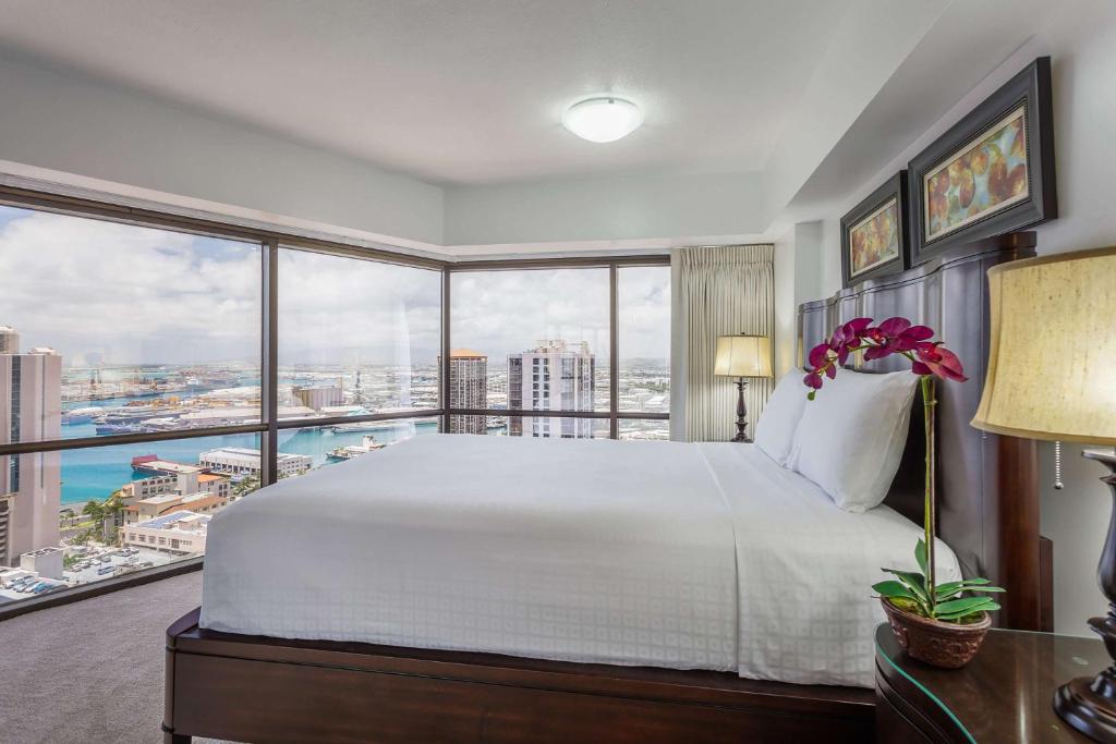 um quarto com uma cama grande e uma janela grande em Aston at the Executive Centre Hotel em Honolulu