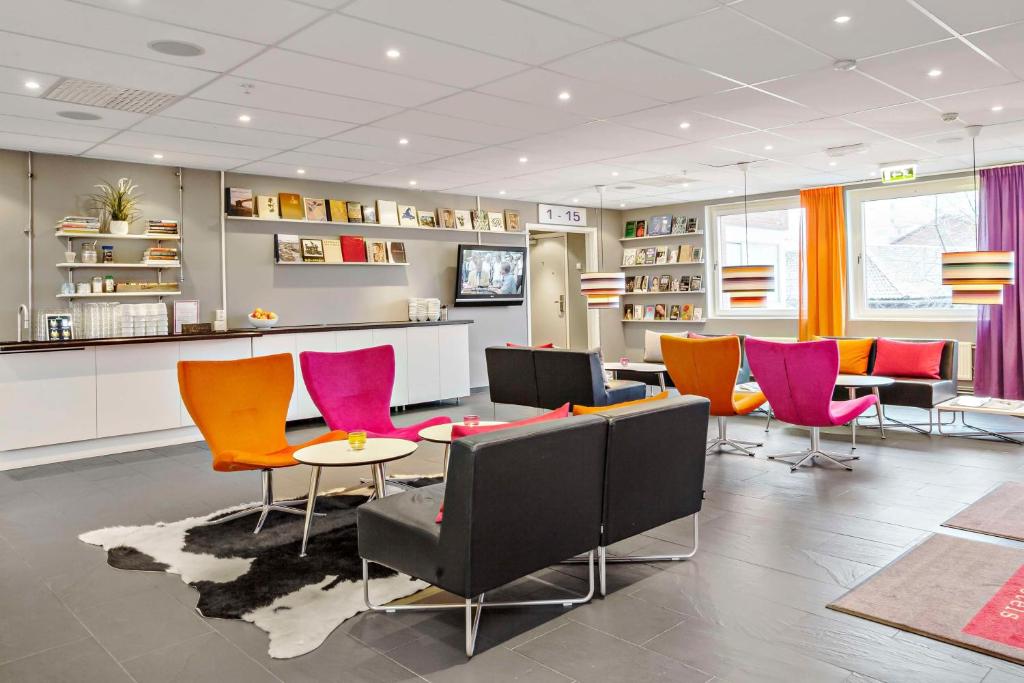 a waiting room with colorful chairs and a table at Sure Hotel by Best Western Stockholm Alvsjo in Stockholm