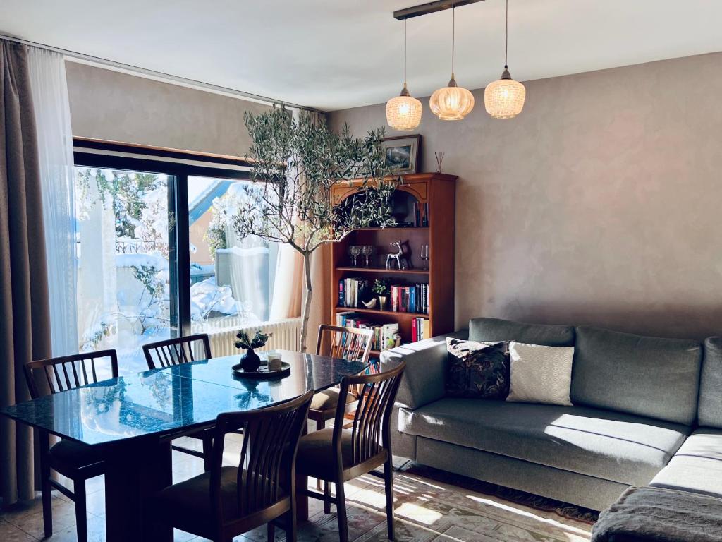 a living room with a table and a couch at Apartments "Lichtenstein Valley" in Unterhausen