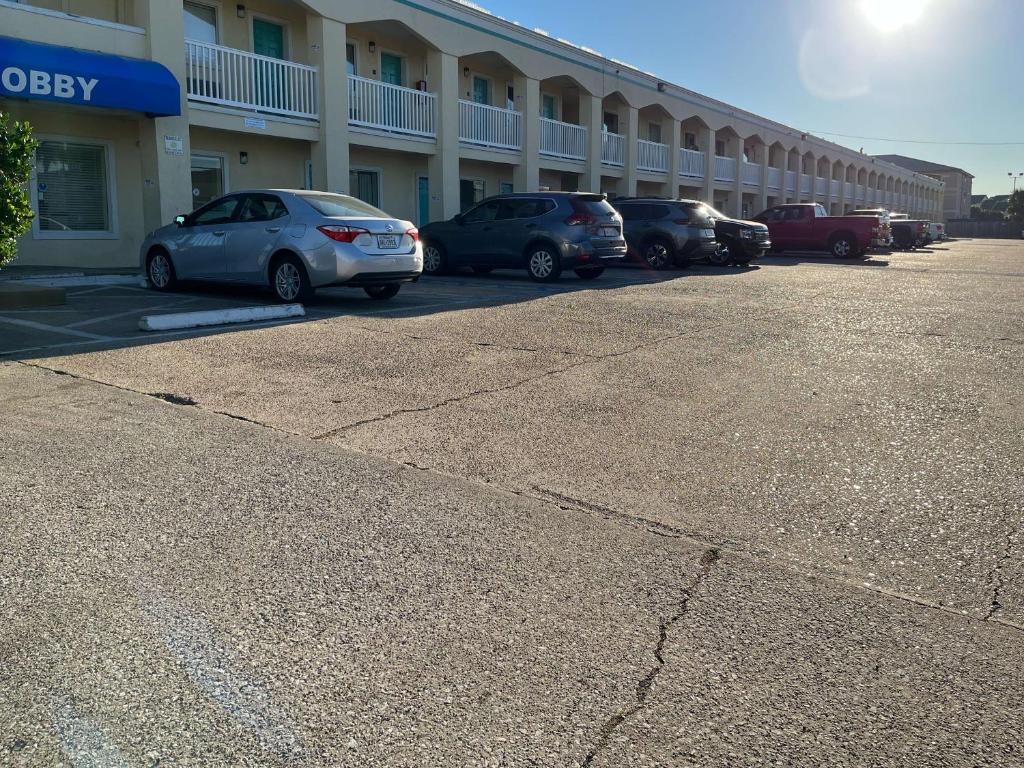 une rangée de voitures garées devant un hôtel dans l'établissement Motel 6 Galveston, TX Seawall, à Galveston