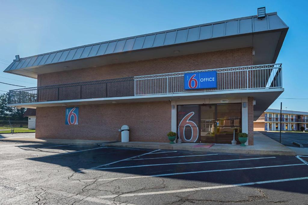 佩里Studio 6 Suites Perry, GA的带阳台的建筑前的商店