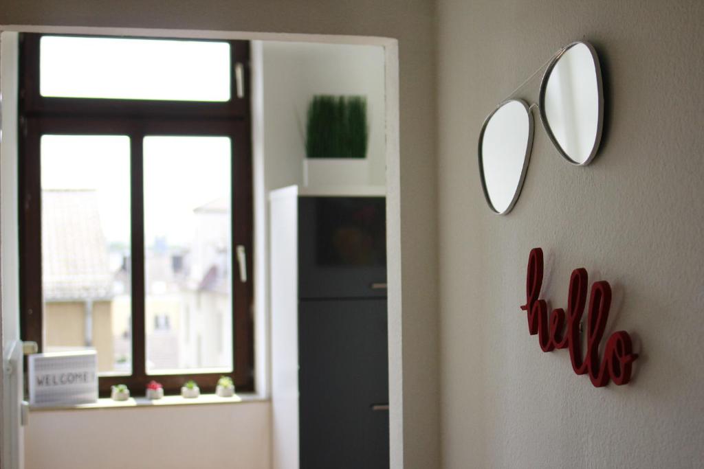 twee spiegels aan de muur van een kamer met een koelkast bij Ferienwohnung 3 ANNA IFF in Würzburg