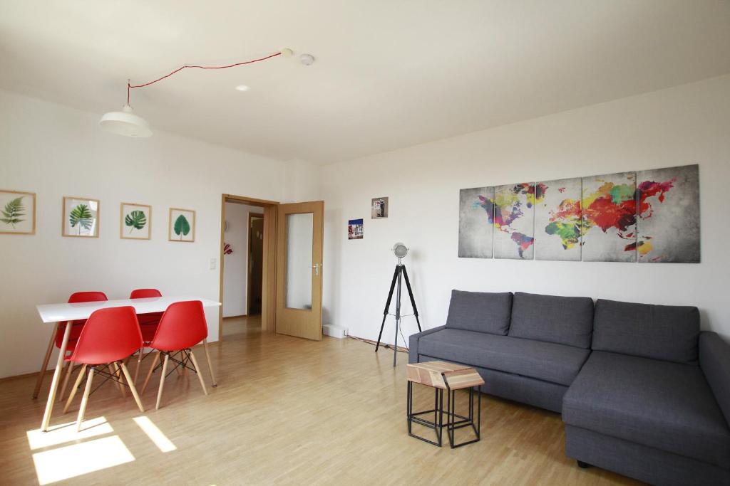 sala de estar con sofá, mesa y sillas rojas en Ferienwohnung 3 ANNA IFF, en Würzburg