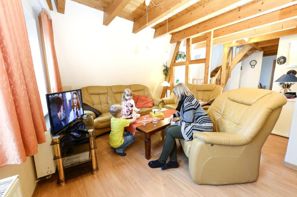 a woman and two children sitting in a living room at Ferienwohnung Luxusdomizil Rathausblick in Otterndorf