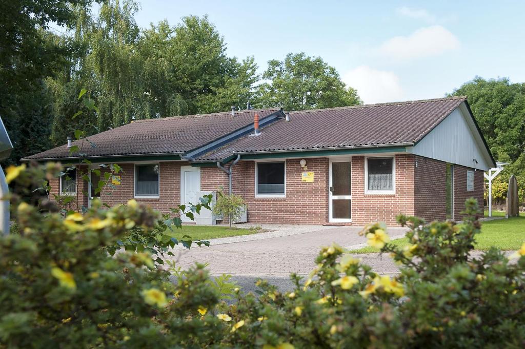 una casa de ladrillo rojo con techo negro en Ferienhaus Seestern I, en Otterndorf